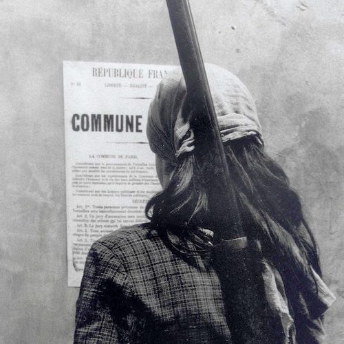 Promotional image from La Commune or a young women reading a broadside, her back to the viewer.